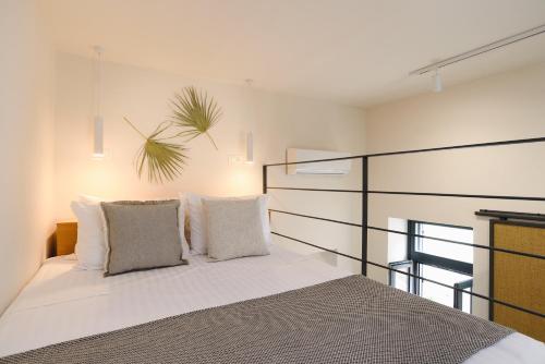 1 dormitorio con 1 cama con sábanas y almohadas blancas en Casa Melenia ''Pilionas'', en Rodas