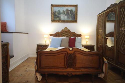 a bedroom with a wooden bed with pillows on it at Antique, Amazing double room in Marques de Pombal with shared Bathroom in Lisbon