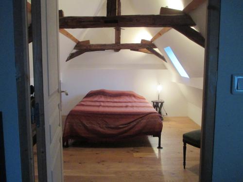 a bedroom with a bed in a attic at La Mazardie in Cubjac