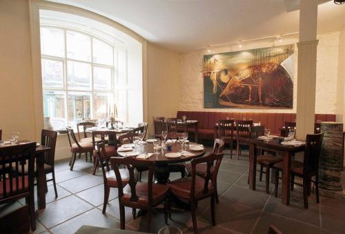 un ristorante con tavoli e sedie e un dipinto sul muro di Old Ground Hotel a Ennis