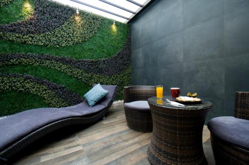 a restaurant with a green wall with chairs and a table at Hotel Catalina in Mexico City
