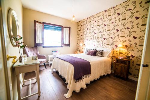 sypialnia z łóżkiem i ścianą z kwiatami w obiekcie Tourist House Santa Maria de Gracia w mieście Carmona