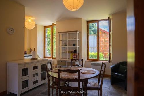 une cuisine avec une table et des chaises dans une pièce dans l'établissement les tilleuls, à Besse-et-Saint-Anastaise