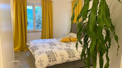 1 dormitorio con cama y planta en Olive House Portoroz, en Portorož