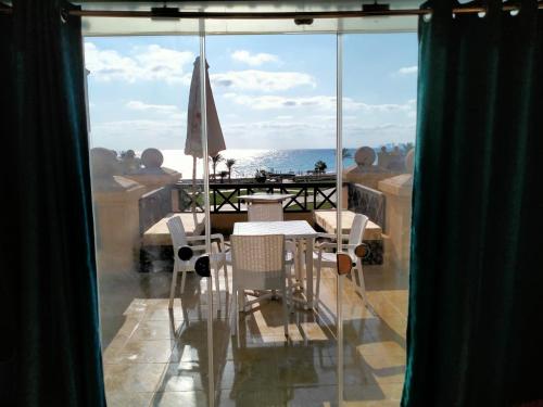 a balcony with a table and chairs and a view of the ocean at Lazorde bay Sidi Abd El Rahman لازوردى باى apartment in El Alamein