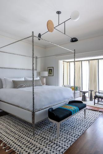 a bedroom with a large white bed with a swing at La Colombe d'Or Hotel in Houston