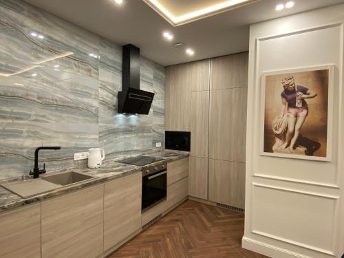 a kitchen with a sink and a painting on the wall at Modern Classic 2 bedroom apartment near Most City in Dnipro