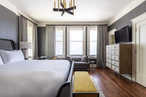 a hotel room with a bed and a chair at La Colombe d'Or Hotel in Houston