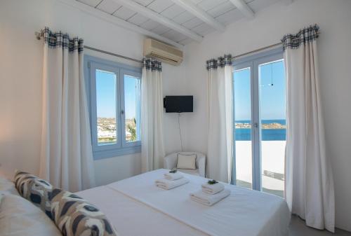 a bedroom with a bed with a view of the ocean at Villa Isabella - Psarou in Psarou