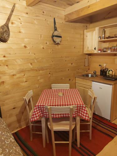 a kitchen with a table and chairs in a cabin at Etno domacinstvo Uvacki konaci in Nova Varoš