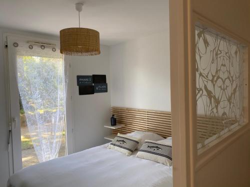 um quarto com uma cama com lençóis brancos e uma janela em Appartement t2 , bord de mer, accès direct plage em Saint-Nazaire