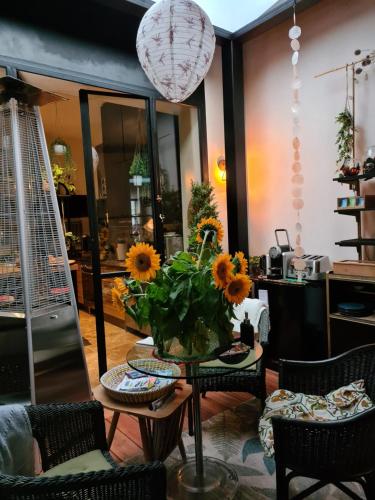 a living room with a table with sunflowers on it at La Belle Amarre-Bed and Breakfast-Maison d'Hôtes in La Rochelle