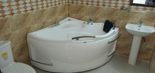 a bathroom with a tub and a sink and a toilet at Marina Beach Villas Resort in Cox's Bazar