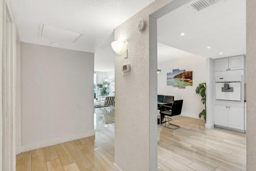a living room with white walls and a table at Sunny Isles Ocean Reserve Condo Apartments in Miami Beach