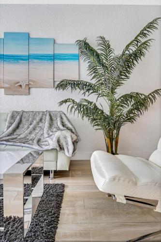 a living room with a palm tree and a white couch at Sunny Isles Ocean Reserve Condo Apartments in Miami Beach