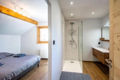 ein Schlafzimmer mit einer Dusche, einem Bett und einem Waschbecken in der Unterkunft Moho Mountain Home in Gérardmer