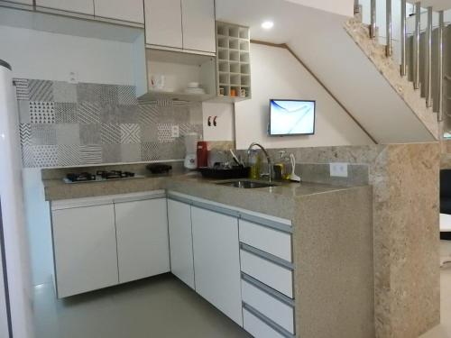 a kitchen with white cabinets and a sink at apartamento 2 quartos em Porto segur BA in Porto Seguro