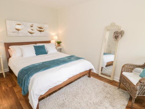 a bedroom with a large bed and a mirror at Beudy Hywel in Caernarfon