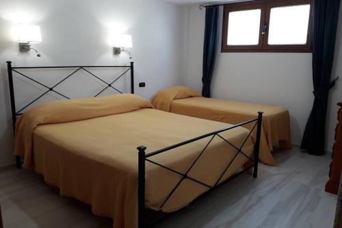 1 dormitorio con 2 camas y ventana en Incantos Charme B&B & Apartment en Tortolì