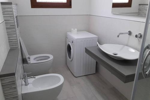 Baño blanco con aseo y lavamanos en Incantos Charme B&B & Apartment, en Tortolì