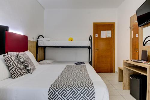 a bedroom with two bunk beds and a tv at Hotel Grazia Riccione in Riccione