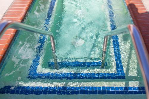 a pool of water with a blue surfboard in it at Avania Inn of Santa Barbara in Santa Barbara