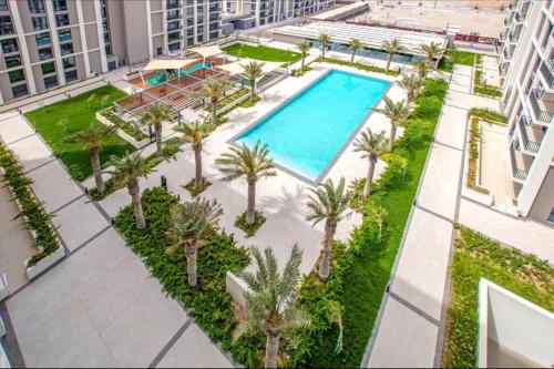 uma vista sobre uma piscina com palmeiras e edifícios em A Luxury Aprt 2 bedrooms Balcony with wonderful view Mall access hi speed WIFI Beach access & much more for Family Only em Rayyā