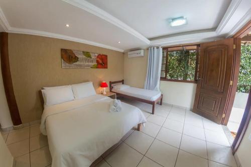 布希奧斯的住宿－Pousada Búzios Garden，卧室设有一张白色大床和一扇窗户。