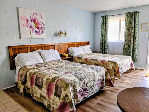 A bed or beds in a room at Jacques Cartier Motel
