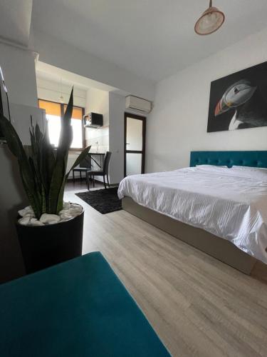 a bedroom with a bed and a table with a potted plant at Le Nid - your central destination in Iaşi
