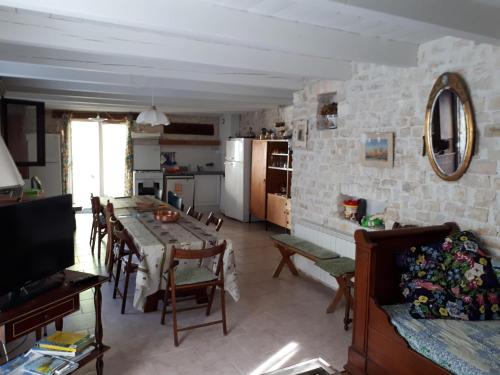 une cuisine et un salon avec une table et des chaises dans l'établissement grange4, à Sainte-Marie de Ré