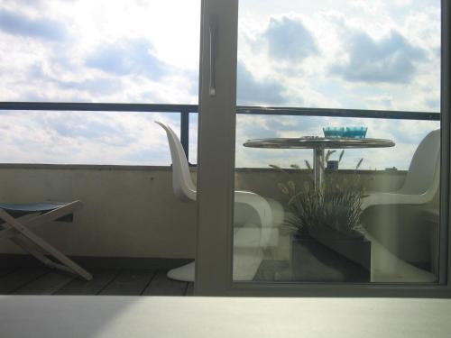 a view of a balcony with a table and a chair at Koksijde l'Abbaye in Koksijde