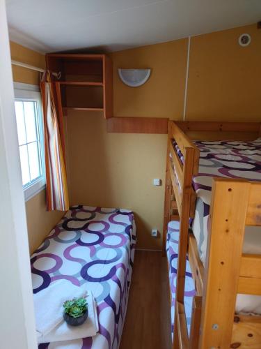 mały pokój z 2 łóżkami piętrowymi i stołem w obiekcie Chalet-home familiar "CAL ÍNDIA" "Pet friendly" w mieście Sant Carles de la Ràpita