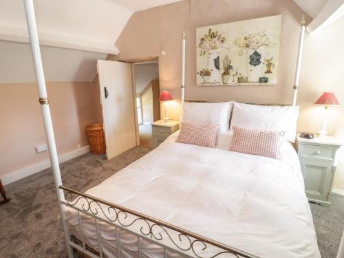 a bedroom with a bed with a white bedspread at Aber Clwyd Manor in Corwen