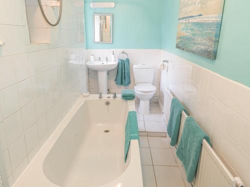 a bathroom with a tub and a sink and a toilet at Aber Clwyd Manor in Corwen