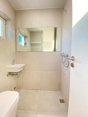 a bathroom with a shower and a toilet and a sink at Arvore Beach House in Árvore