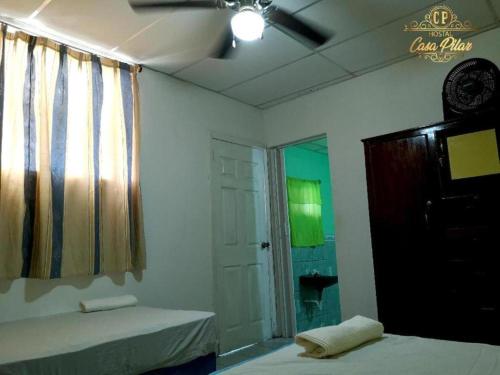 a room with two beds and a window and a bathroom at HOSTAL CASA PILAR in Masaya