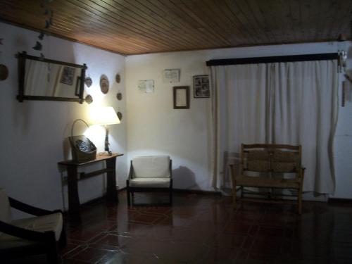 a living room with a chair and a table and a window at Hotel La Posta del Dayman in Termas del Daymán