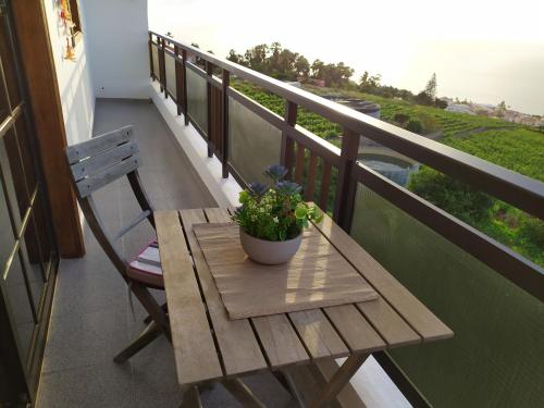 a wooden table on a balcony with a plant on it at Los atardeceres más bellos del Sauzal in Sauzal