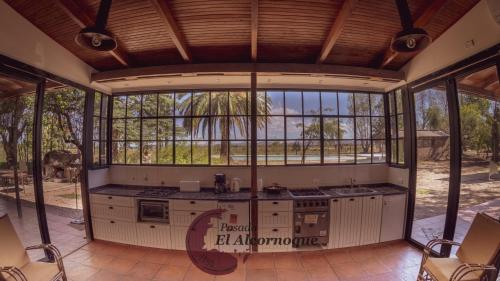 uma cozinha em plano aberto com janelas e um balcão em Posada El Alcornoque em São Rafael