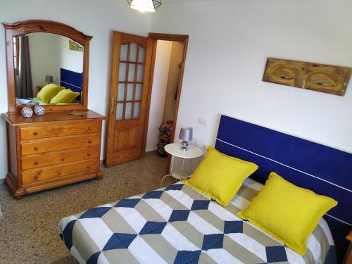 サウサルにあるLos atardeceres más bellos del Sauzalのベッドルーム1室(黄色い枕と鏡付きのベッド1台付)