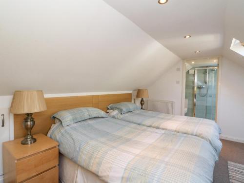 a bedroom with a bed and a glass shower at Hayloft in Pittenweem
