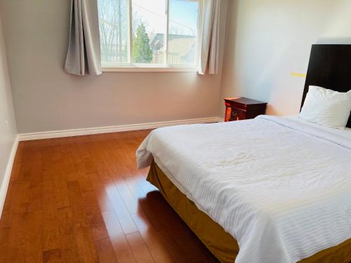 a bedroom with a large bed and a window at A1 Holiday Family House in Niagara Falls