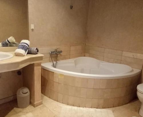 een badkamer met een bad, een toilet en een wastafel bij Taouima bienvenue in Nador