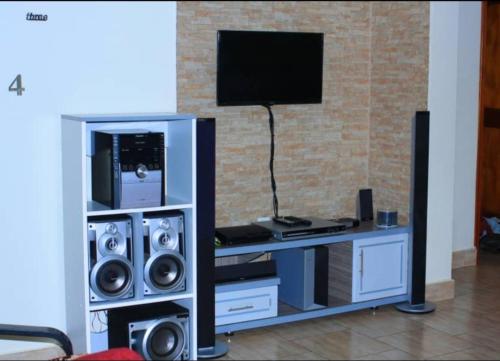 a room with a entertainment center with speakers and a tv at DREAM APARTMENTS UGANDA in Kampala