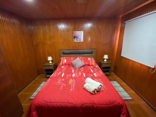 a bedroom with a red bed with two night stands at Depto N°4 Temuco Centro in Temuco