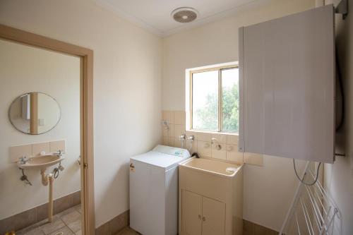 a bathroom with a sink, toilet, and cabinet at Lakeview Motel and Apartments in Robe