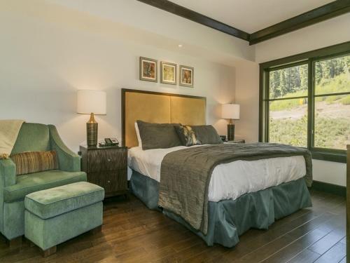 特拉基的住宿－Luxurious 3 Bedroom With Ski in & out Access condo，一间卧室配有一张大床和一把椅子