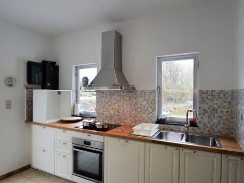 a kitchen with a sink and a stove at Nature Retreat by the Lakes in Rosée