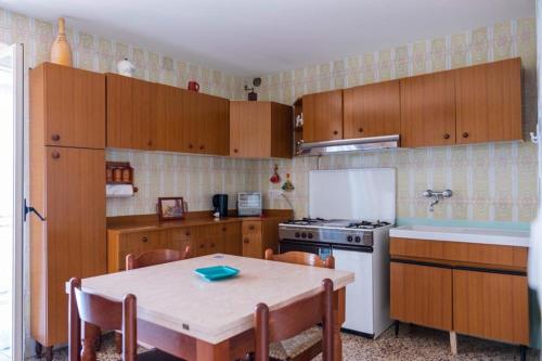 a kitchen with wooden cabinets and a table and a stove at Appartamento Andrea in Ravello